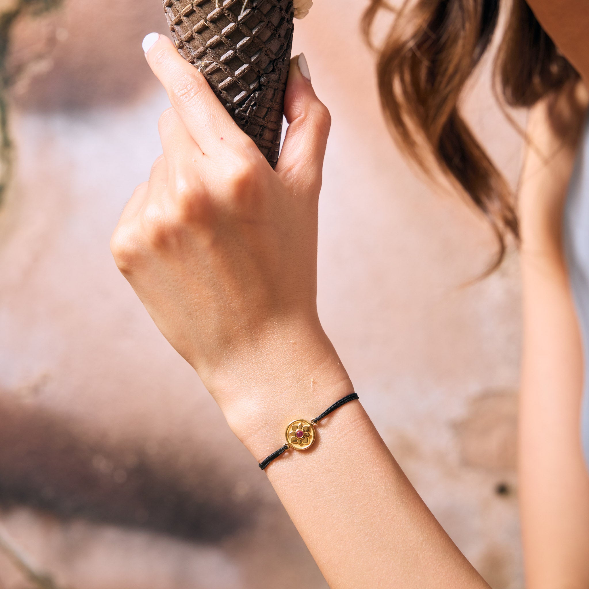 Female model wearing a gold lotus bracelet
