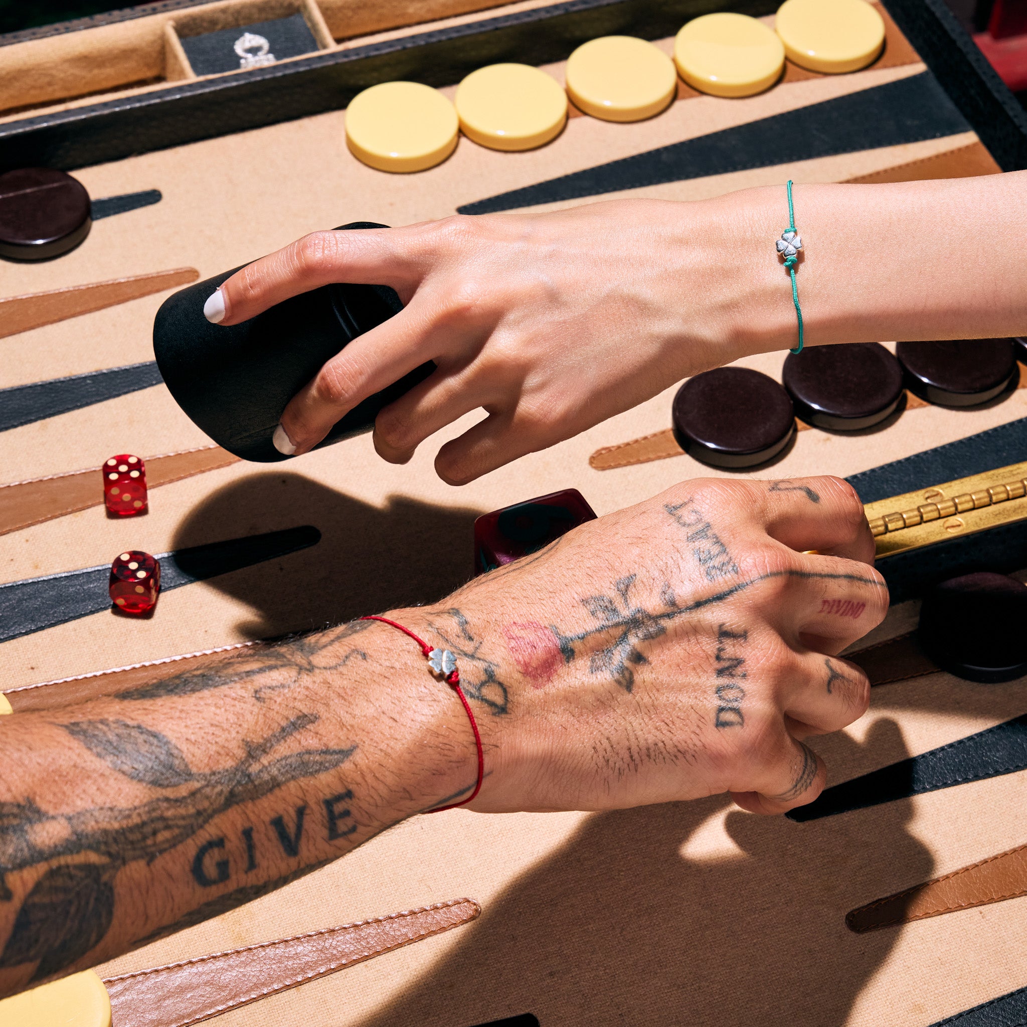 Male and Female Models Playing Backgammon and Wearing Lucky Clover Bracelets