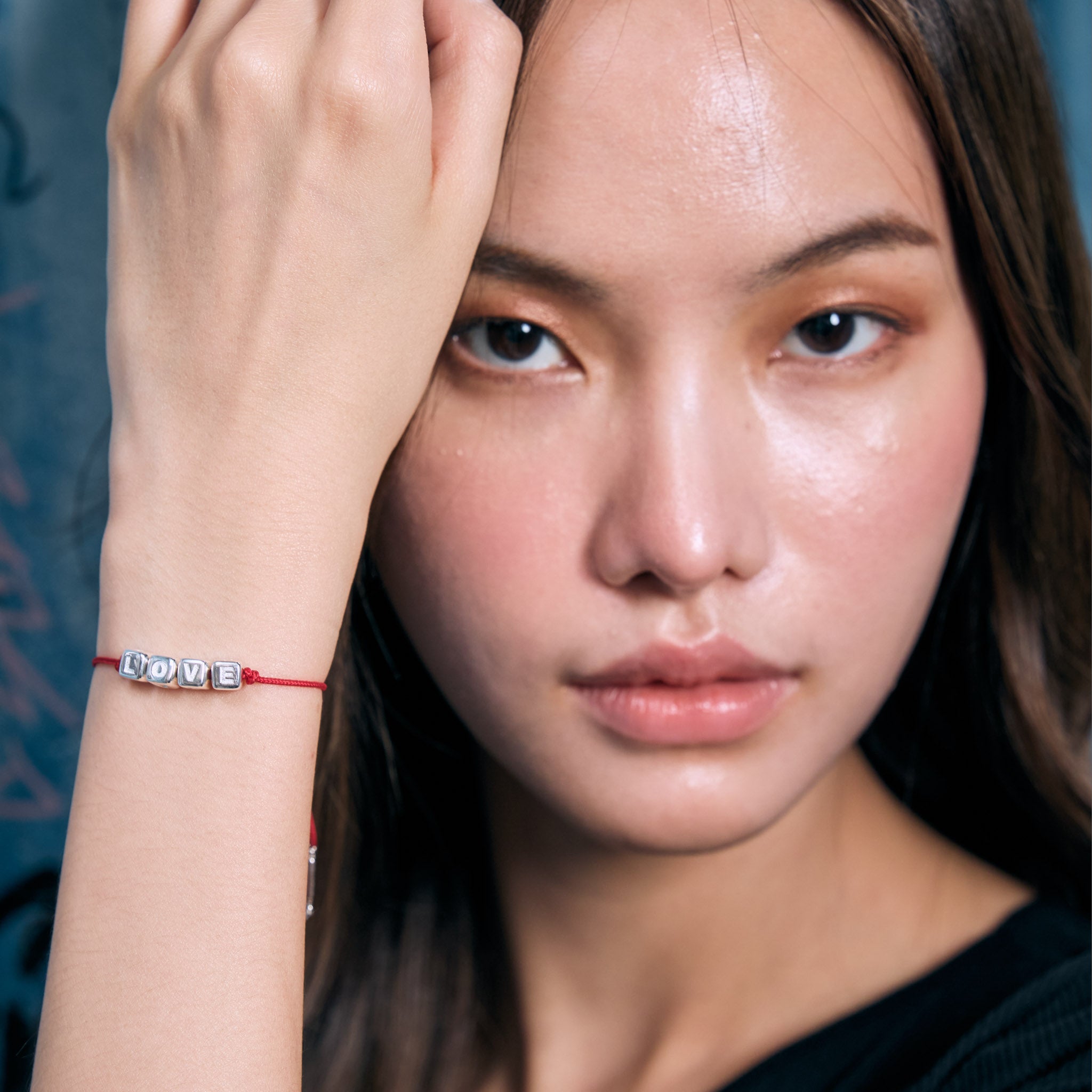Woman wearing a red 'LOVE' bracelet