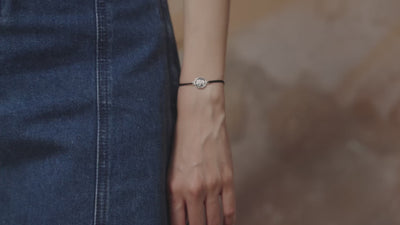 Video of a female model wearing a bracelet with a silver elephant charm
